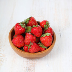 Ripe strawberries in a brown bowl
