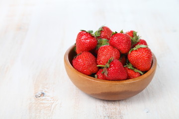 Ripe strawberries in a brown bowl