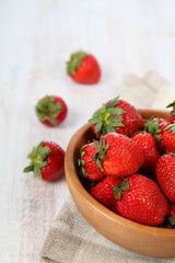 Ripe strawberries in a brown bowl