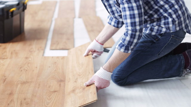 close up of man installing wood flooring