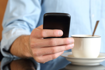 Close up of a hand using a smart phone at breakfast