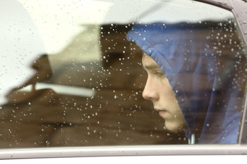 Sad teenager boy worried inside a car