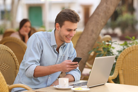 Self Employed Man Working With A Laptop And A Phone In A Restaurant