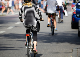 Blonde woman with helmet on bike in traffic