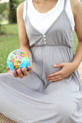 Pregnant women show Globe model in hand.