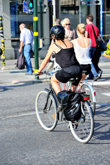 Fototapeta na wymiar Scandinavian blonde girl on bike, wearing helmet