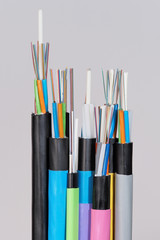 Group of 7 different fiber optic cable  ends with stripped jacket layers and exposed colored...