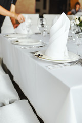 White napkin nicely folded on the plates, serving a celebratory banquet