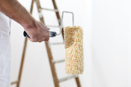 Painter Man At Work With A Paint Roller And Ladder,  Close Up