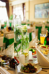 Nice flowers in vases like decorations on the table with food in a restaurant on the wedding