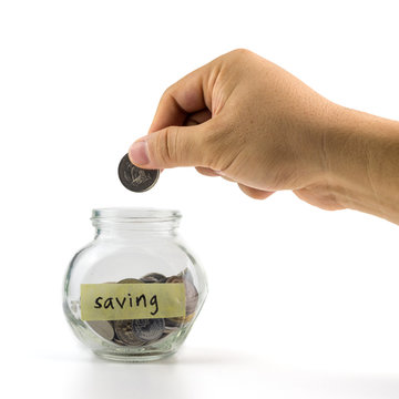 Hand putting coin into glass container with  saving label on white background.