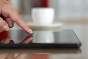 Female hand pointing in black tablet pc
