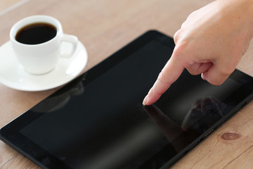Female hand pointing in black tablet pc