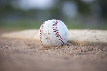 Selective focus low angle of grungy baseball and base