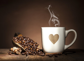 White cup with heart and coffee beans
