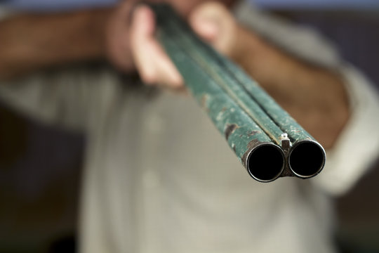 Gunpoint of double-barreled shotgun, pointing to camera