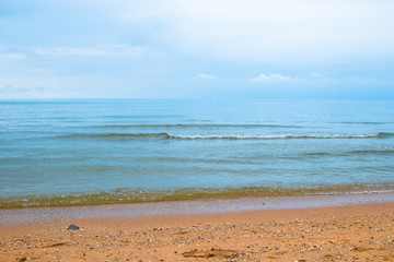 shore beach with traces of legs and a calm sea