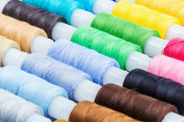 Fototapeta na wymiar Multicolor sewing threads on background