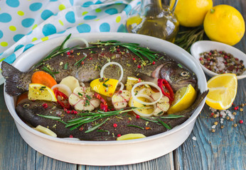 Two fresh rainbow trout with lemon, rosemary and spices