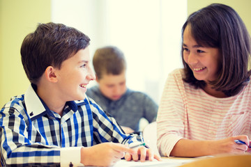 group of school kids writing test in classroom