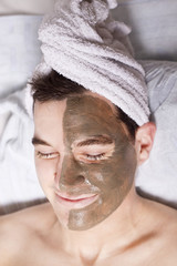 man with a mud mask on this face