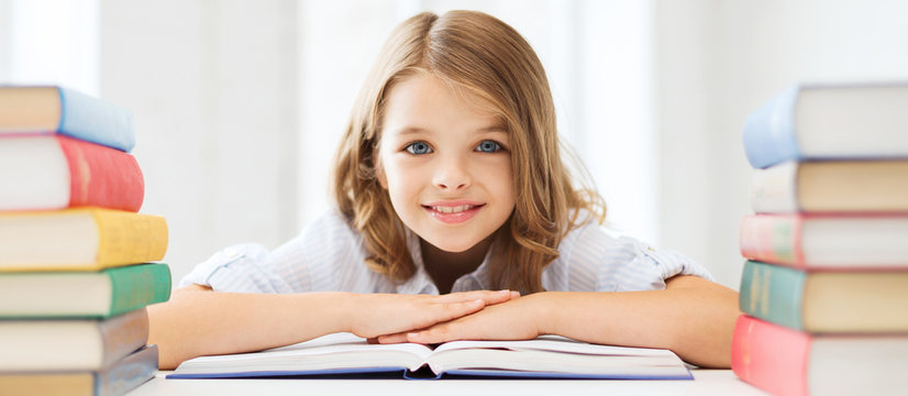 smiling little student girl with many books