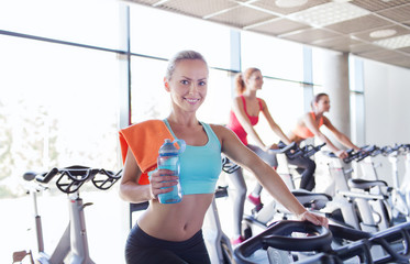 Fototapeta premium group of women riding on exercise bike in gym