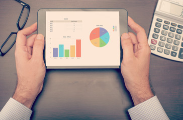 Businessman checking statistics on tablet device