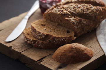 Dark multigrain bread whole grain and jam fresh baked on rustic