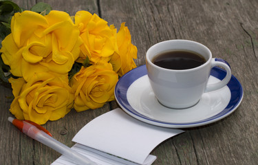 notebook with the handle, coffee and a bouquet of bright yellow