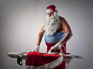 Santa Claus doing the ironing - obrazy, fototapety, plakaty