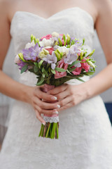 Obraz na płótnie Canvas Wedding bouquet at bride's hands