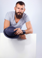 Portrait of young man in hat standing near blank, isolated on