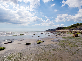 Tide out on the Jurassic Coast near Lyme Regis, Dorset. Sandly beach with rocks.