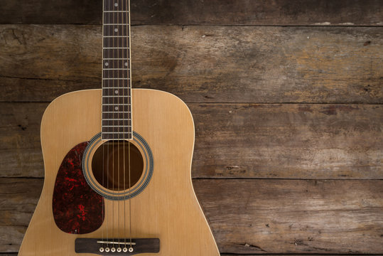 Top view of guitar on dark wood floor texture in darken tone