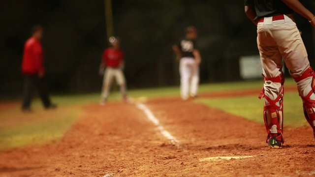Batter hitting ball and player running to home during a baseball game