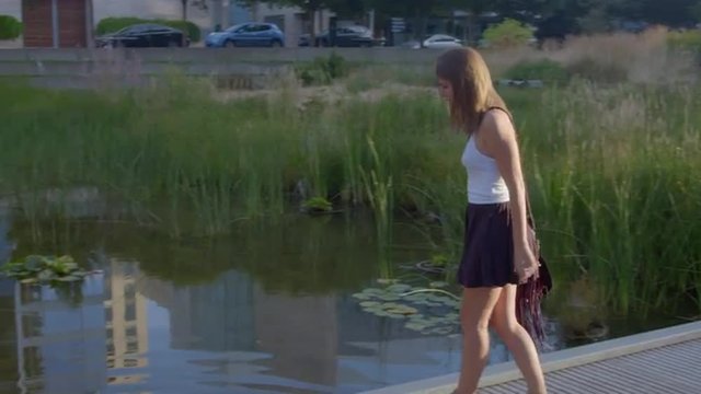 Attractive girl walks around looking at fish 