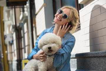 Cute blonde with Bichon Frise white dog