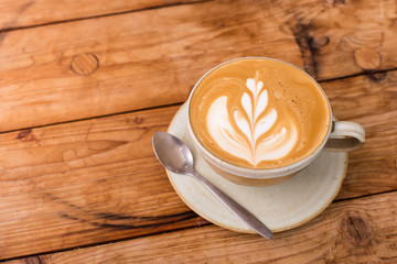 Hot art Latte Coffee in a cup on wooden table.