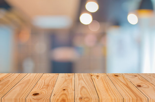 Selected focus empty brown wooden table and Coffee shop blur bac