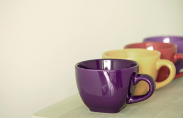row of colorful cups on wooden table
