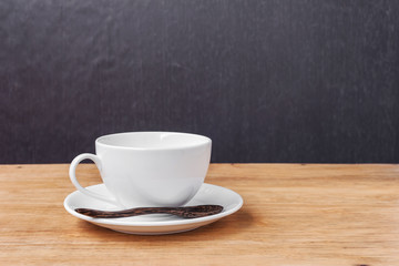 Fototapeta premium White cup of a coffee on a wooden