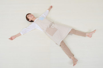 フローリングに寝転ぶ女性