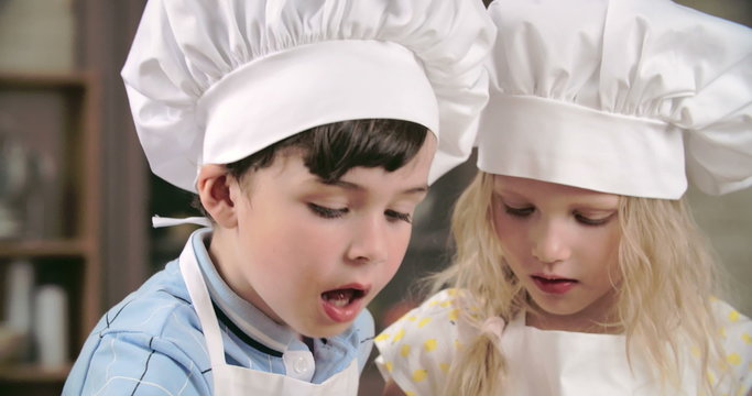 Adorable children tasting sweets in cooking class 
