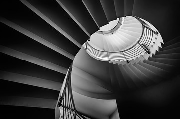 Black and white photograph of spiraling staircase shot from low angle. - Powered by Adobe