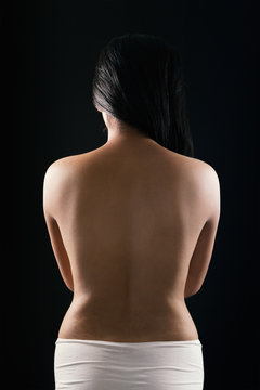 Close up sexy back of young Asian woman in white pantie isolated over black background.
