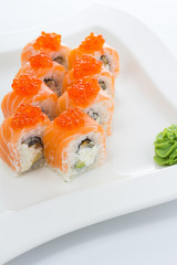 Salmon (philadelphia) sushi roll on a white plate with ginger and wasabi