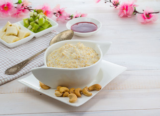 Porridge with kiwi and banana over wooden vintage background