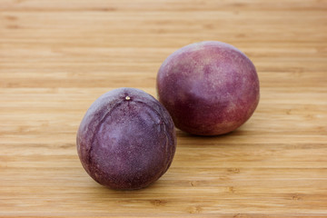 Close-up of two whole passion fruits (passionfruit, purple granadilla (Passiflora edulis)) on a...