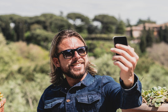 Casual Man With Long Blonde Hair And Beard Making Selfie Outdoor